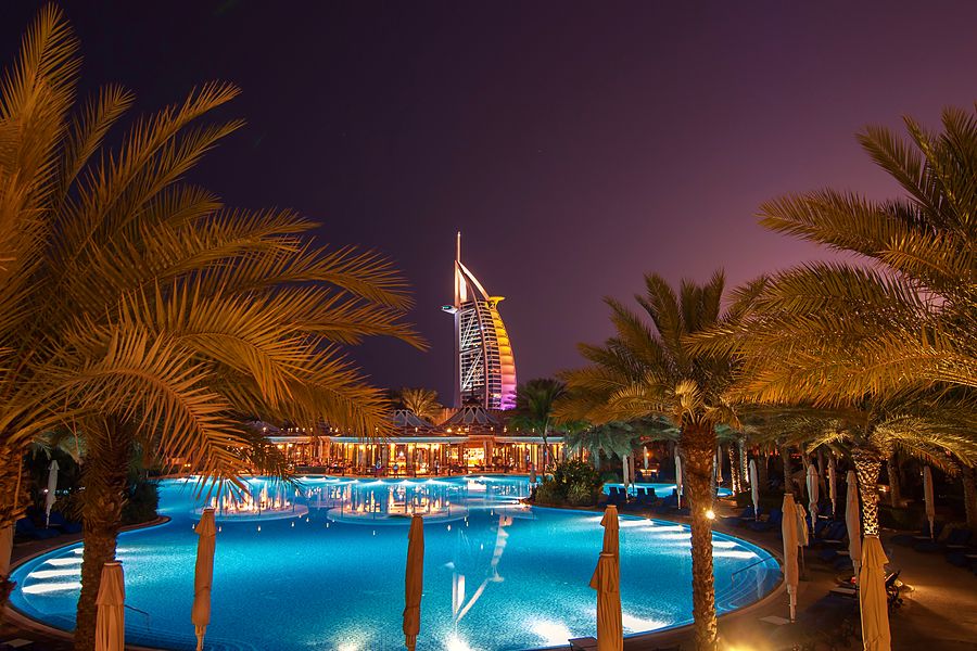 El hotel Burj Al Arab entre palmeras y piscinas al atardecer